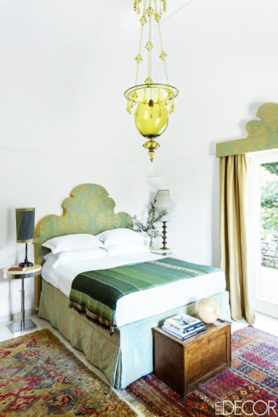 Bright green glass pendant and green silk headboard and bedskirt in a serene island home on Capri.