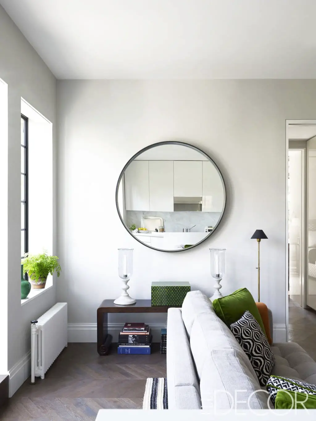 A clean modern living room vignette, with a circular mirror.