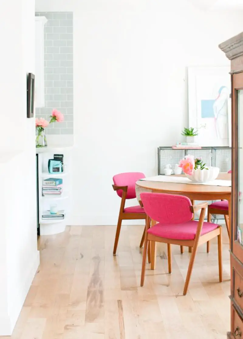 Modern dining room with pop of bright pink chairs.