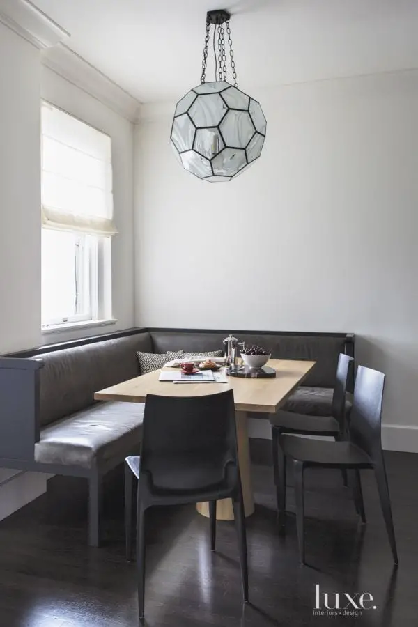 A simple modern dining nook with banquette and pendant light.