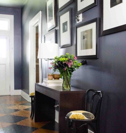 Moody charcoal entry hallway with black and white gallery wall by Kevin O'Gara on Thou Swell #hallway #greyhall #greyhallway #hallwaydesign #greywalls #greypaint #homedesign