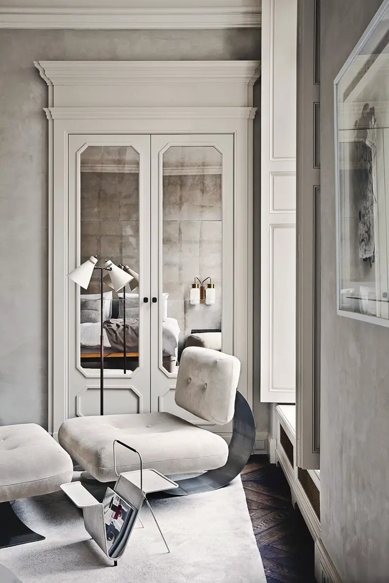A luxurious, gray bedroom with textured walls and mirrored doors.