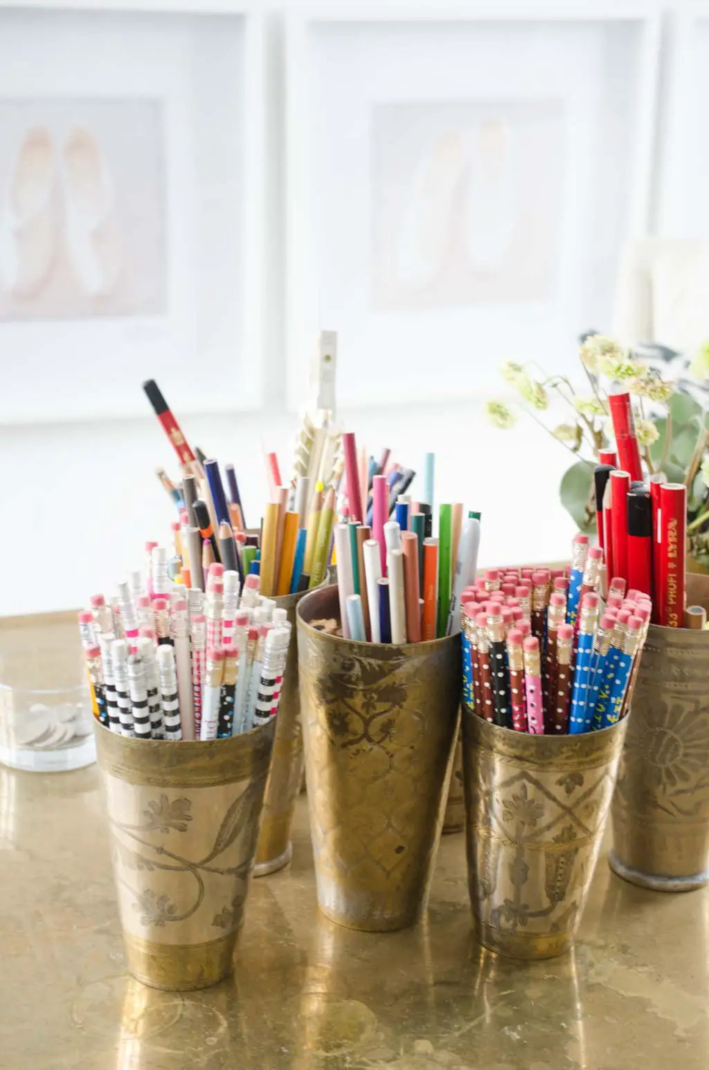 Brass desk with cups of pens and pencils on @thouswellblog