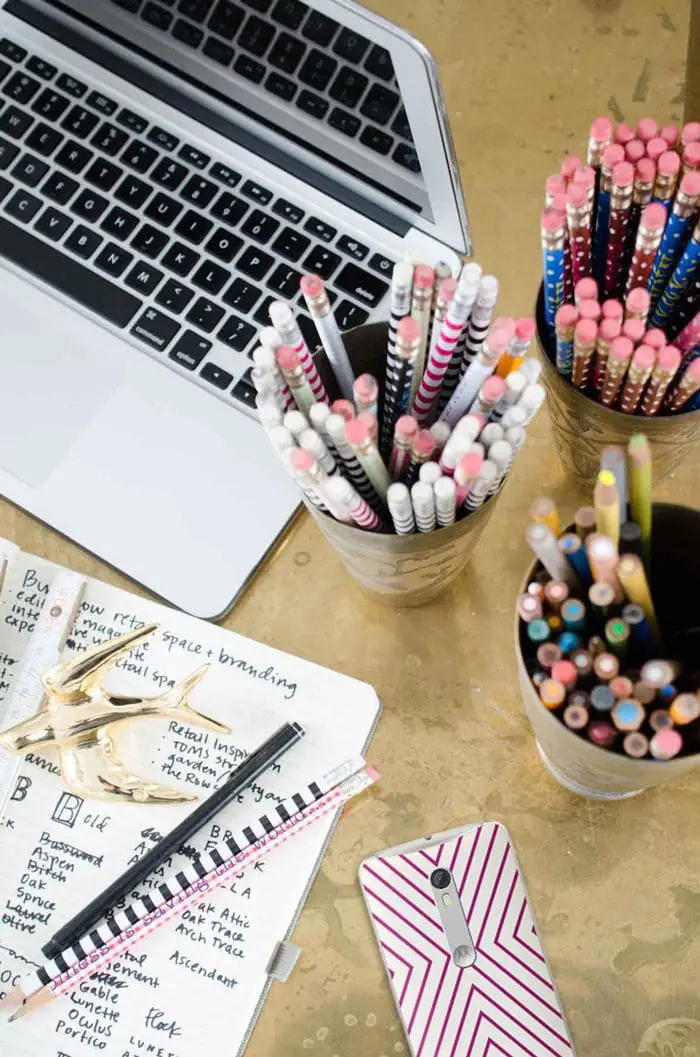 Brass desk with cups of pens and pencils and Jonathan Adler Moto X on @thouswellblog