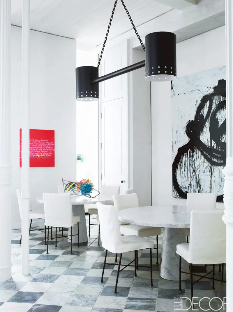 A modern dining room with two tulip tables and modern art via @thouswellblog