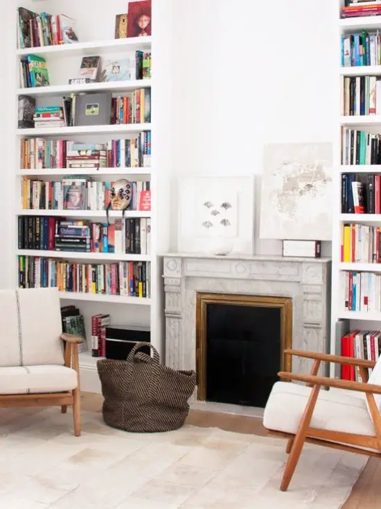 Bookcases surround the fireplace in a neutral living room in Madrid via @thouswellblog
