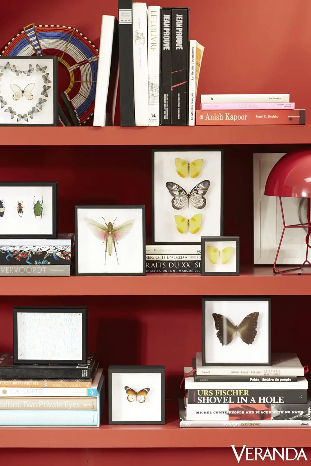 Red bookshelf with framed butterflies on @thouswellblog