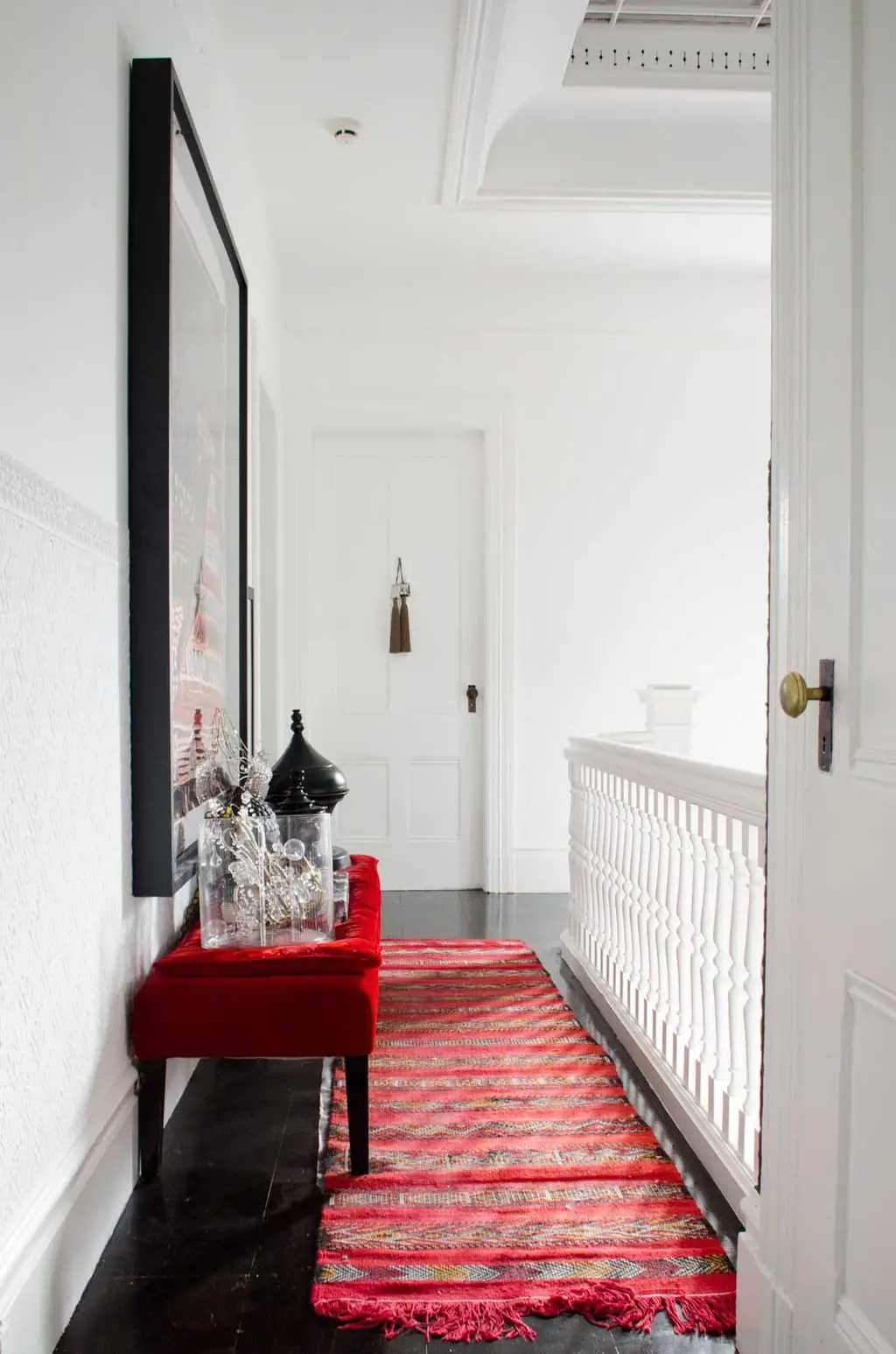 White hallway with red runner on @thouswellblog