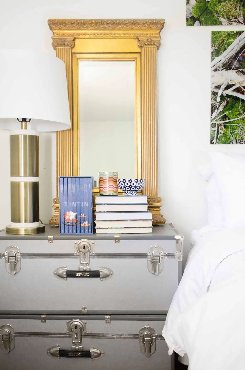 Eclectic bedroom with stacked trunks bedside table and gold mirror via @thouswellblog