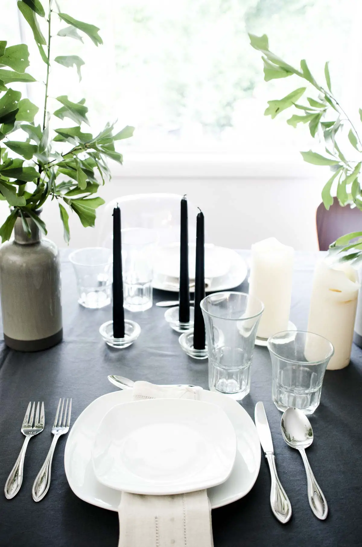 Scandinavian-inspired black, white, and grey summer table setting with simple green arrangements via @thouswellblog
