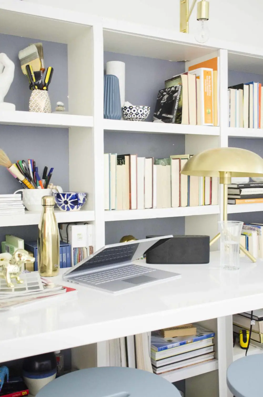 Modern standing desk home office with bookshelves on @thouswellblog
