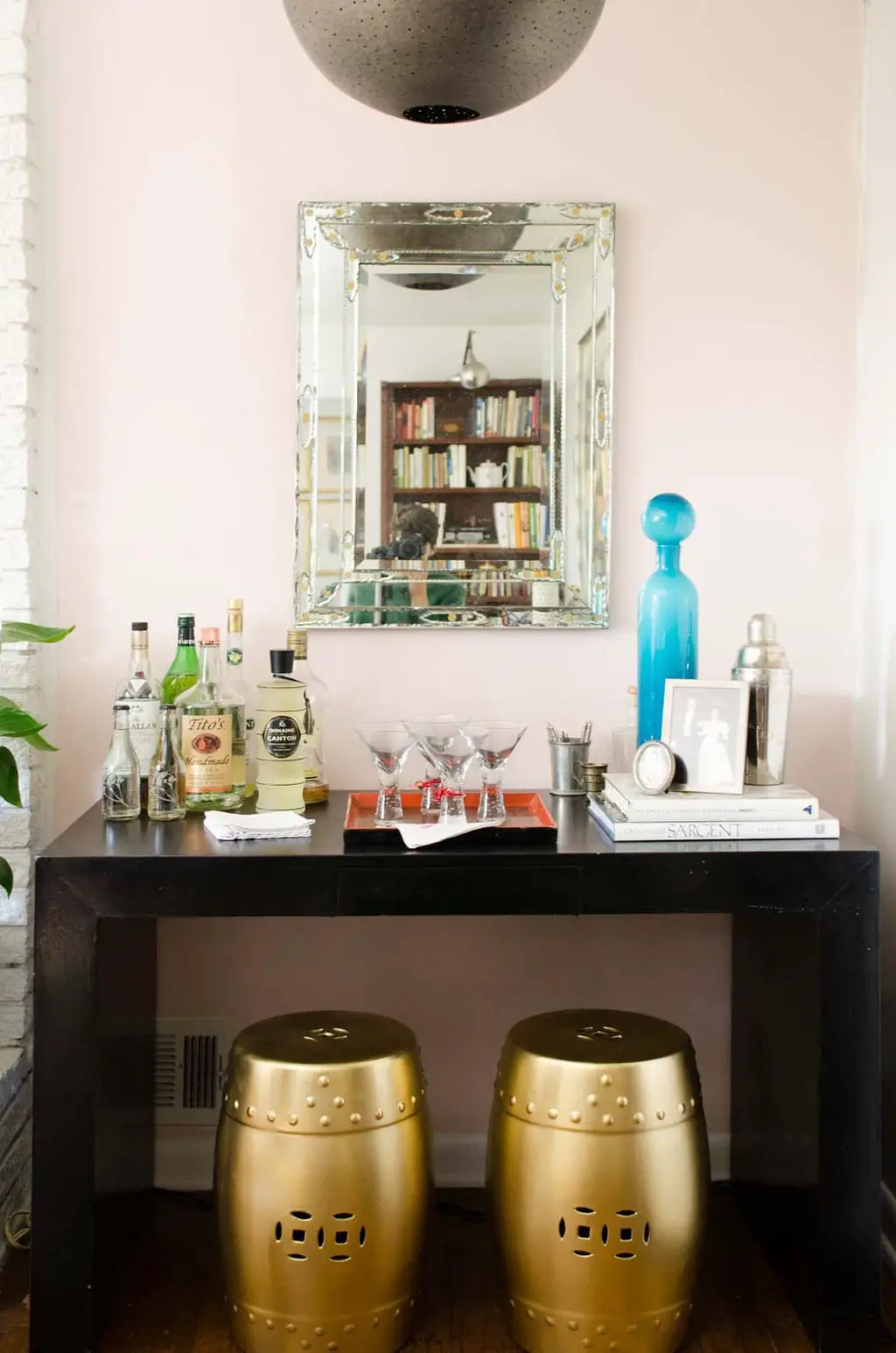 Bar with black parsons table and pink accent wall via @thouswellblog