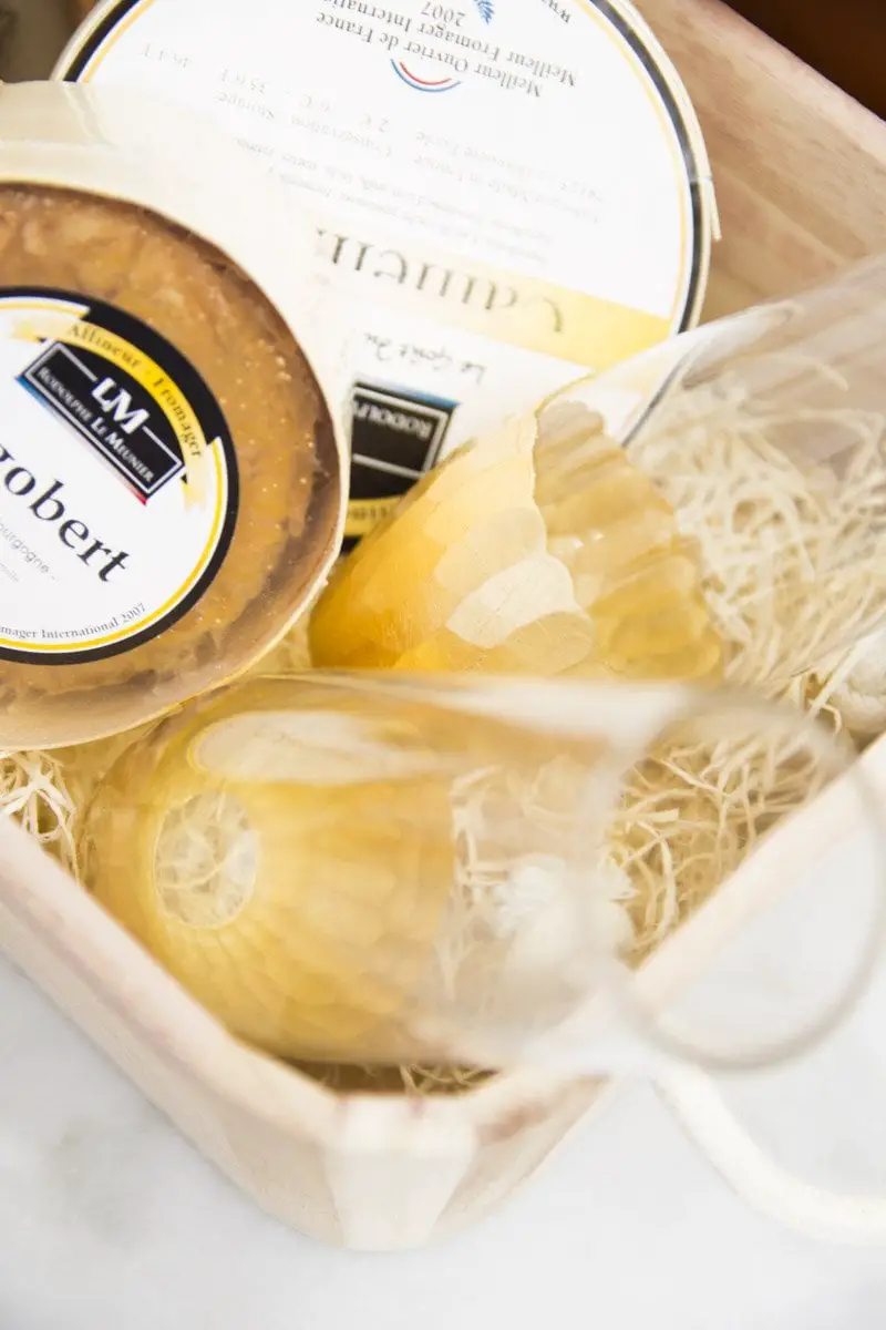 Gift basket with cheese, knives, tea towel, and champagne flutes from World Market on Thou Swell