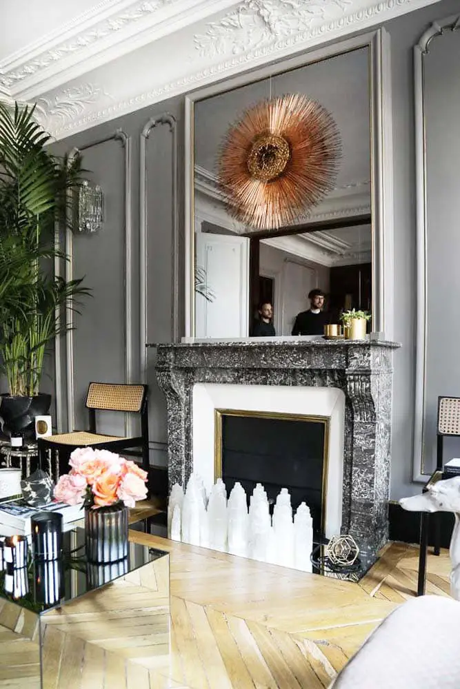Grey living room in Paris pied-à-terre with sunburst mirror and chevron flooring on Thou Swell @thouswellblog