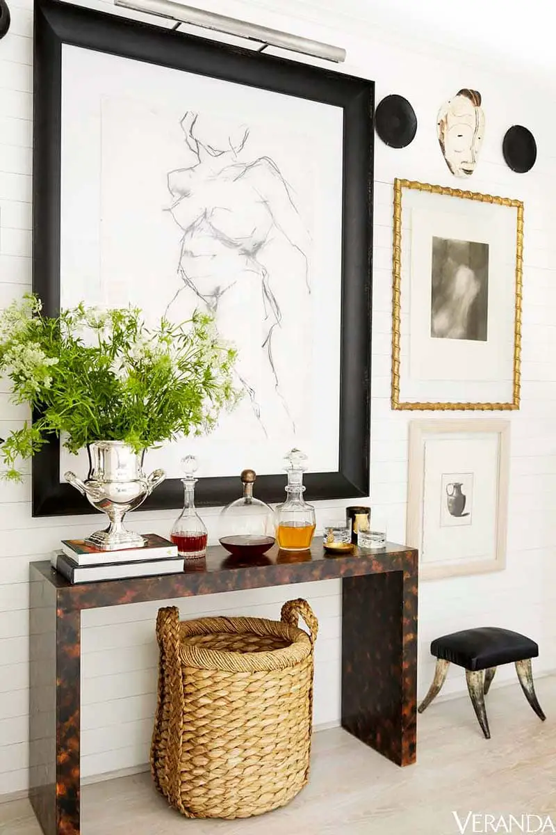Burl console table with eclectic art and wicker basket on Thou Swell @thouswellblog