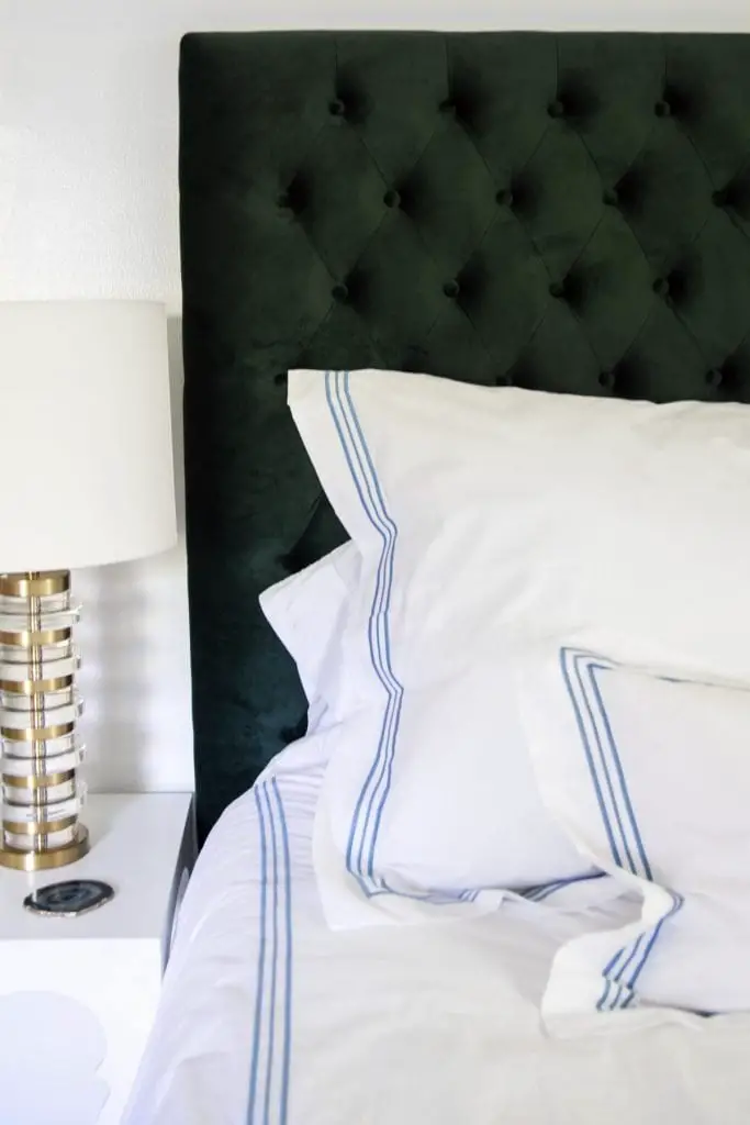 Green tufted headboard with blue trio bedding and gold lamp on Thou Swell @thouswellblog