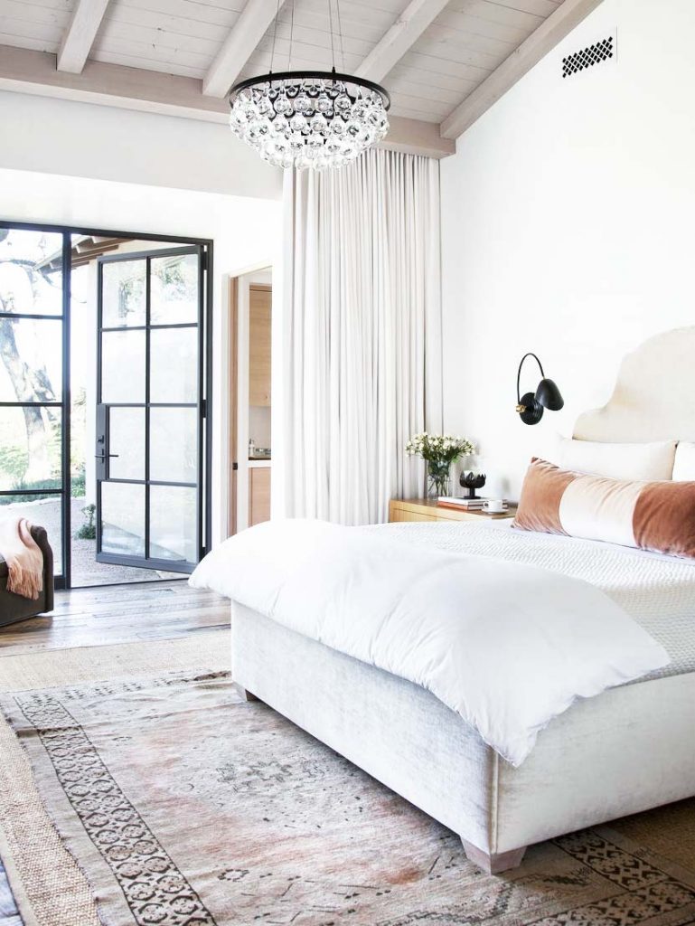 Master bedroom with modern crystal chandelier and black sconces on Thou Swell @thouswellblog