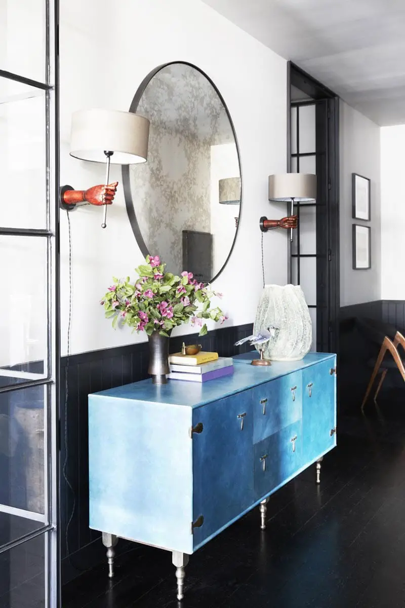 Blue console table in industrial modern hallway vignette decor with round mirror and hand sconces on Thou Swell @thouswellblog