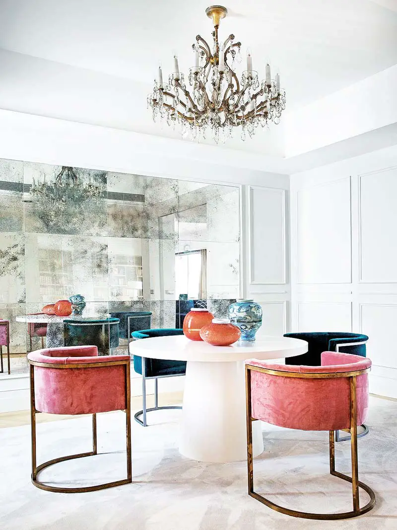 Glamorous dining room with pink velvet dining chairs and mirrored wall on Thou Swell @thouswellblog