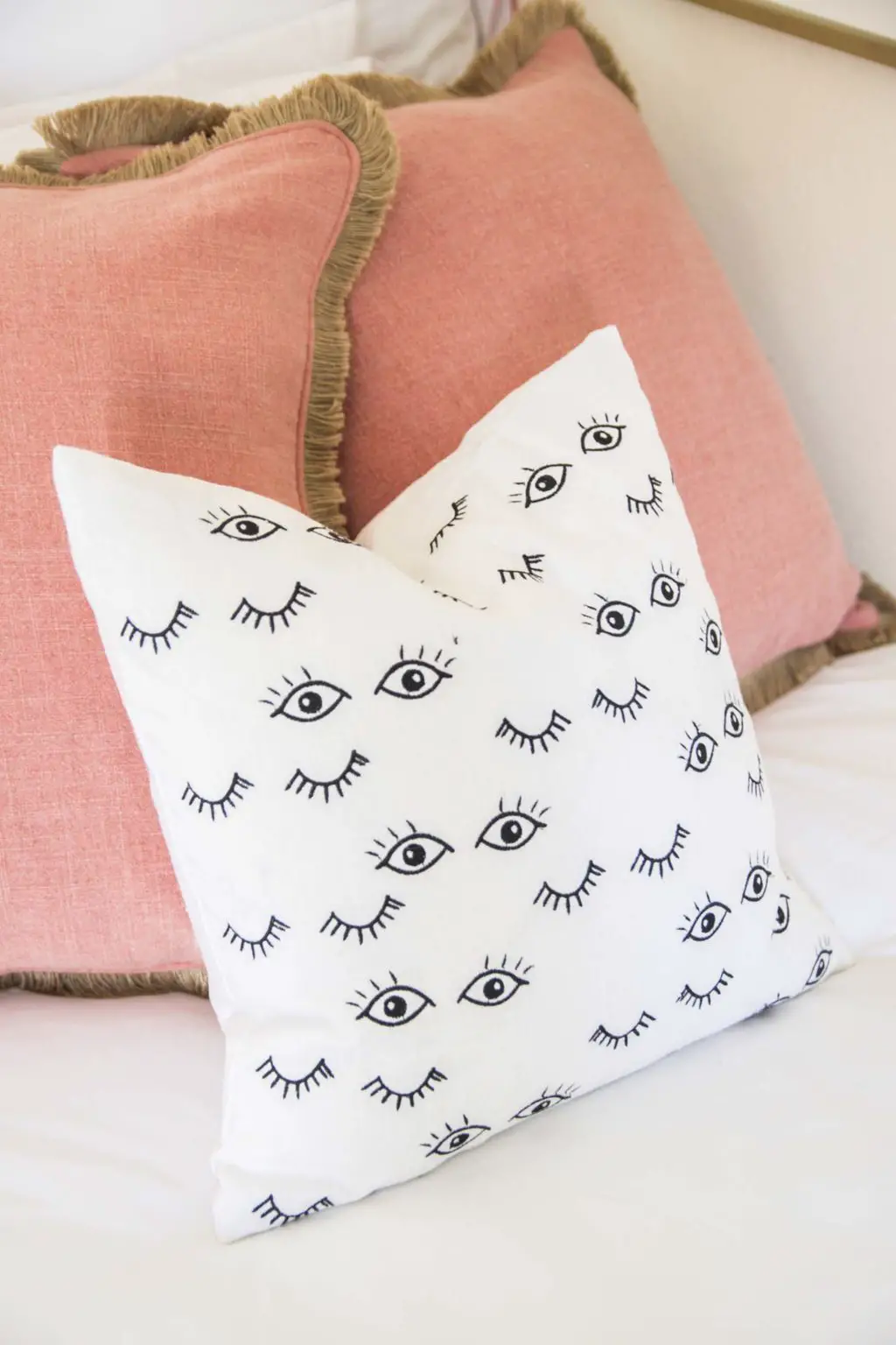 Pink fringe throw pillows on bed with eye pillow on Thou Swell @thouswellblog
