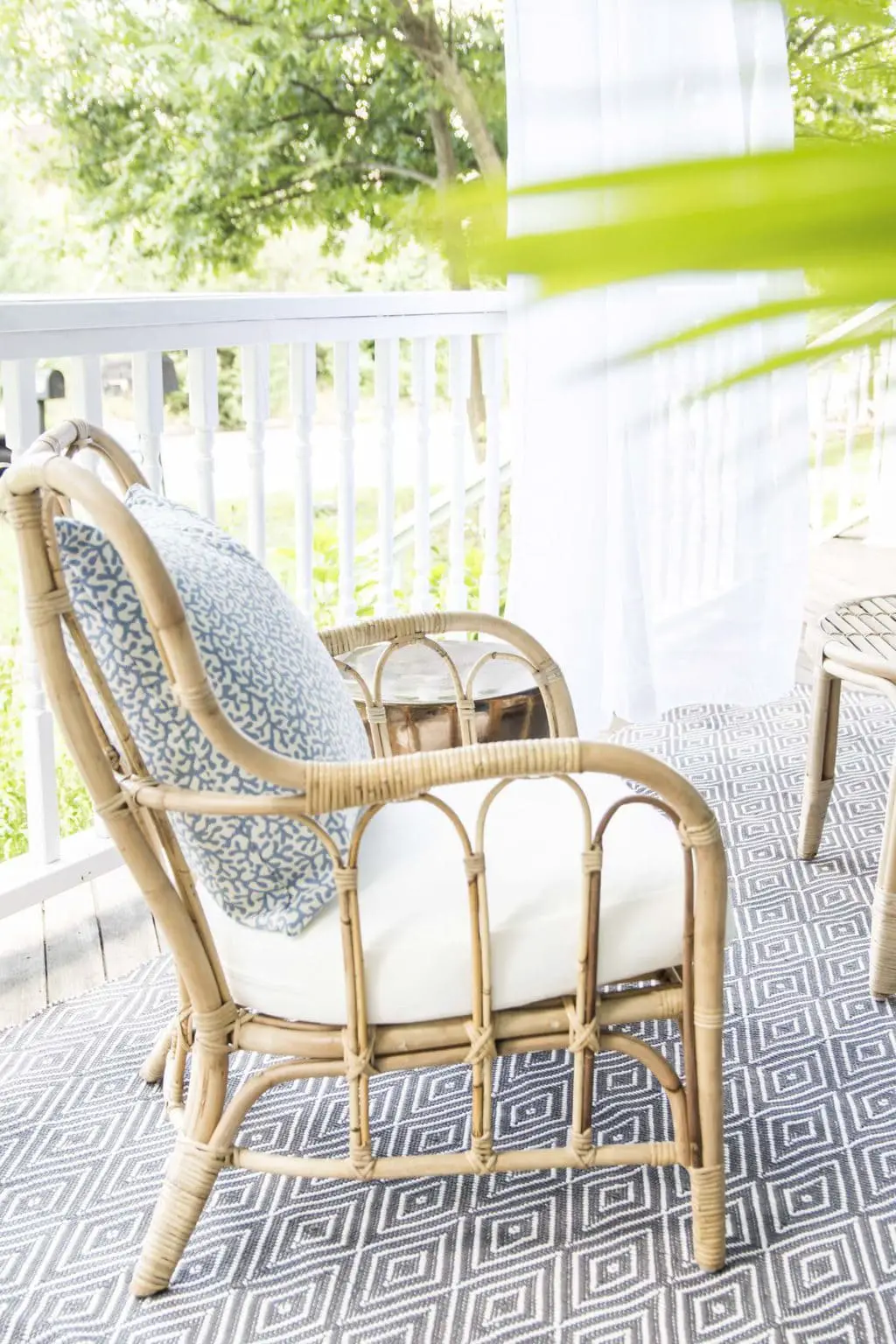 Rattan armchair with DecoratorsBest outdoor throw pillow, blue porch makeover on Thou Swell @thouswellblog