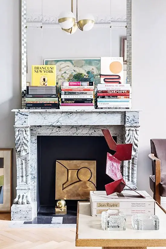 Carved fireplace mantel with stacks of books on Thou Swell @thouswellblog