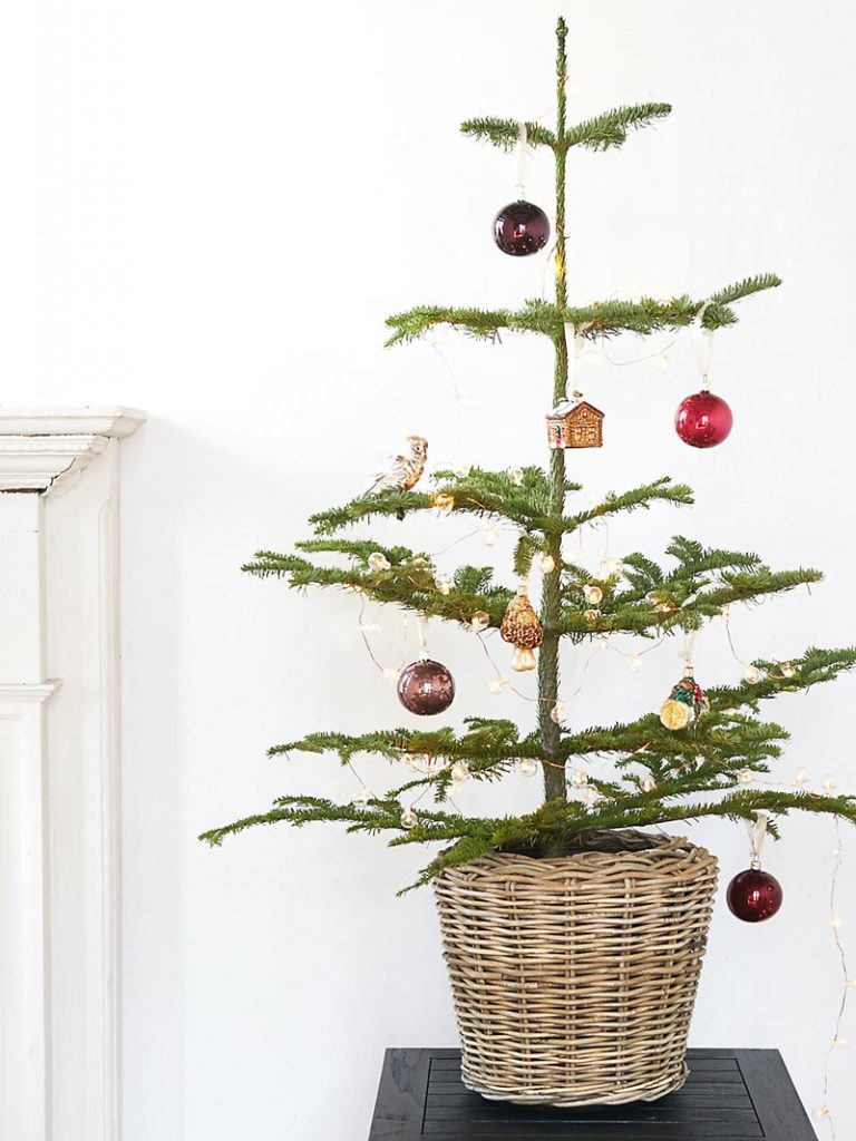 Christmas tree in basket with unique ornaments on Thou Swell @thouswellblog