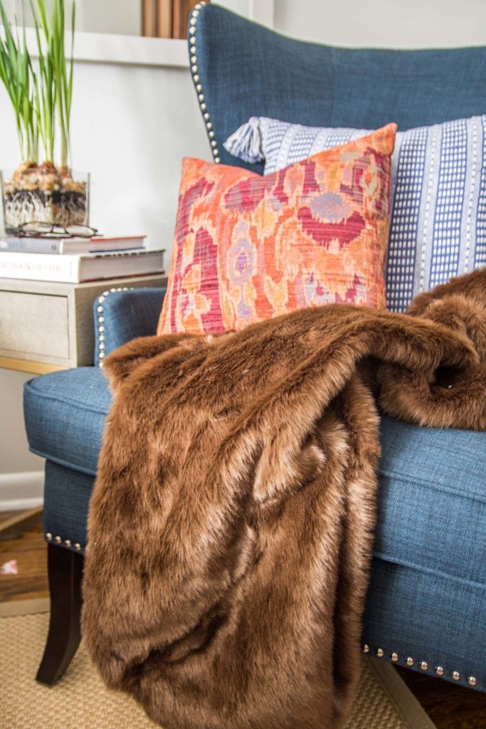 Brown faux fur throw and patterned pillows in a wingback accent chair on Thou Swell @thouswellblog