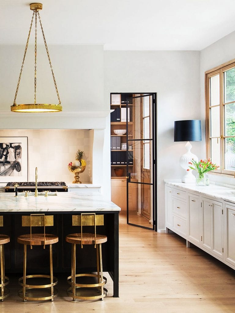 Beautiful modern kitchen with brass counter stools, pendant, and table lamp with black shade on Thou Swell @thouswellblog