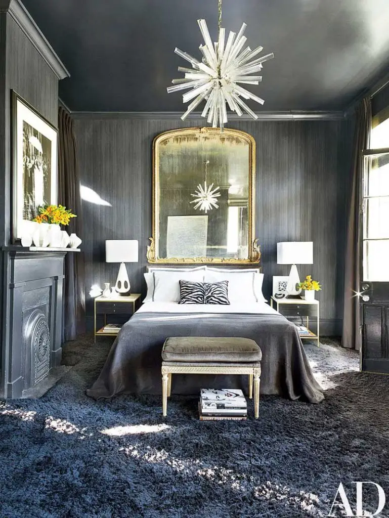 Fabulous grey bedroom in New Orleans with lucite chandelier and gold mirror on Thou Swell @thouswellblog