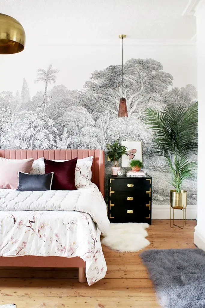 Tropical bohemian bedroom makeover with pink velvet bed and black campaign nightstand on Thou Swell @thouswellblog