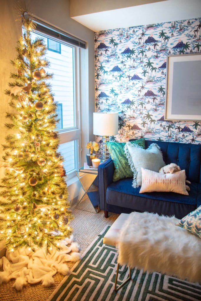 Playful apartment Christmas tree with whimsical blush ornaments and bird decorations in a tropical living room design on Thou Swell @thouswellblog