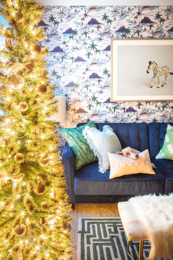 Playful apartment Christmas tree with whimsical blush ornaments and bird decorations in a tropical living room design on Thou Swell @thouswellblog