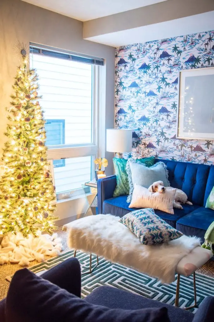Playful apartment Christmas tree with whimsical blush ornaments and bird decorations in a tropical living room design on Thou Swell @thouswellblog