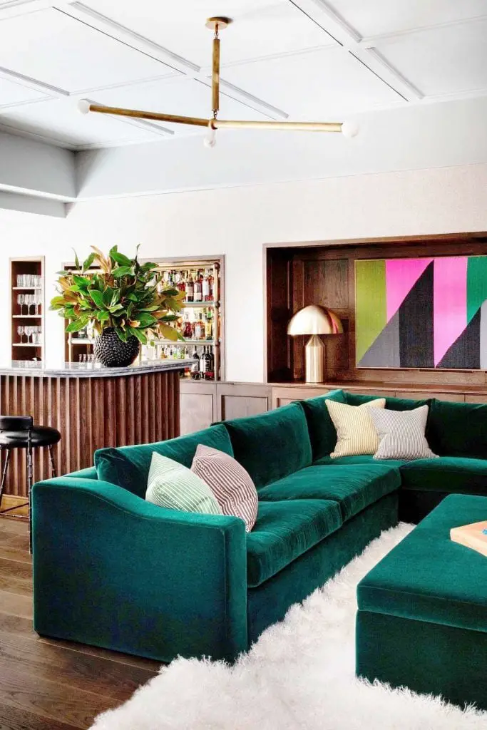 Gorgeous green velvet sectional with shag rug and custom bar on Thou Swell @thouswellblog
