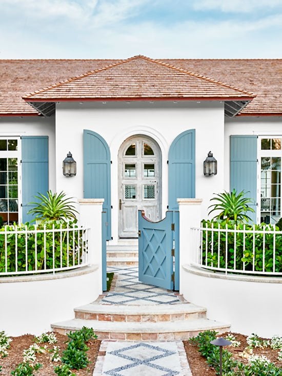 Stucco beach house exterior with blue shutters in Palm Beach on Thou Swell #hometour #palmbeach #exterior #coastaldecor