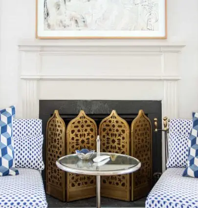 Navy dot slipper chairs in white living room with Moroccan fireplace screen on Thou Swell #livingroom #livingroomdesign #fireplacedesign