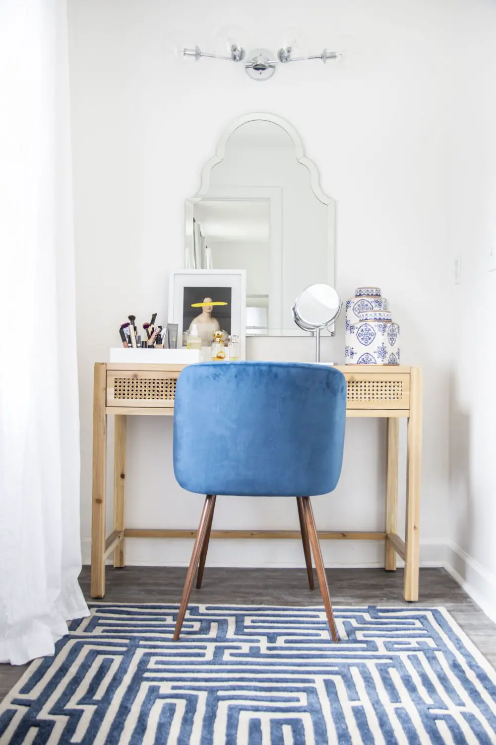 Blue and white vanity room in master suite with cane console desk, blue velvet chair, and Moroccan mirror on Thou Swell @thouswellblog #vanity #vanityroom #vanitydesign #masterbedroom #mastersuite #interior #interiordesign