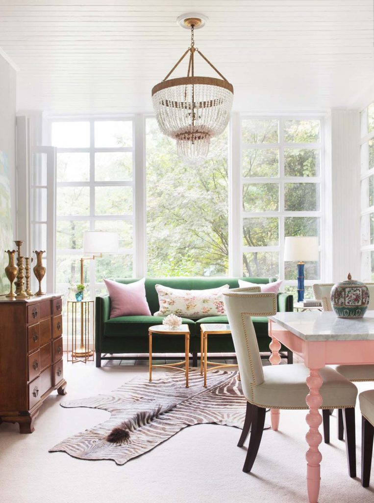 Playful Druid Hills family room in Atlanta with green velvet sofa, pink dining table, and zebra hide rug on Thou Swell #familyroom #druidhills #atlantahome #atlantahomes #familyroomdesign #interiordesign #greensofa