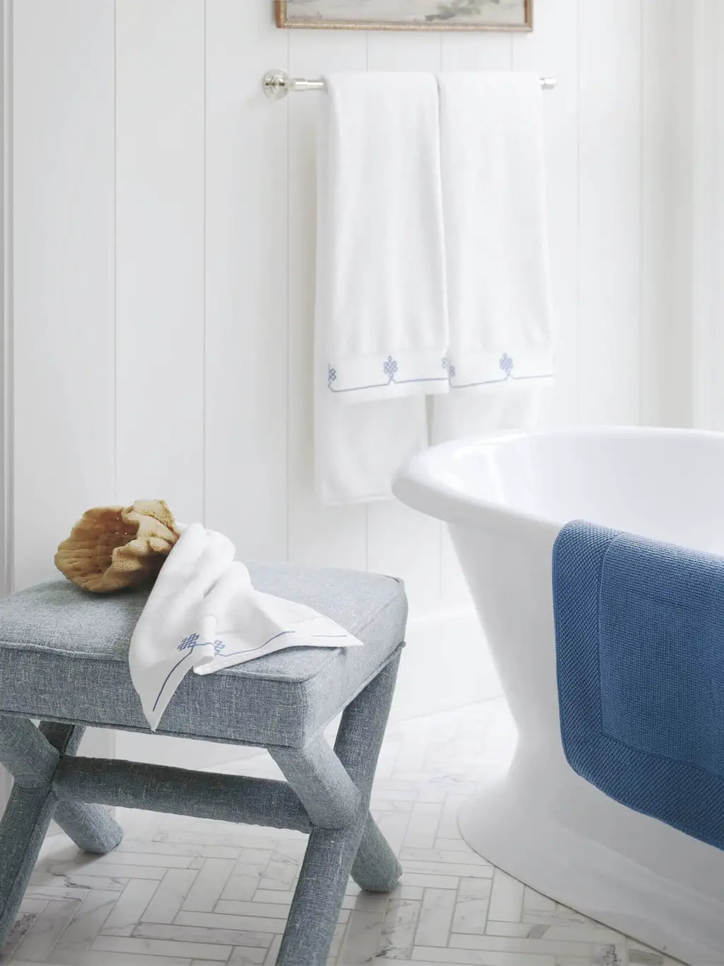 Classic blue and white bathroom with upholstered x bench by the bathtub on Thou Swell #bathroom #blueandwhite #bathtub #xbench