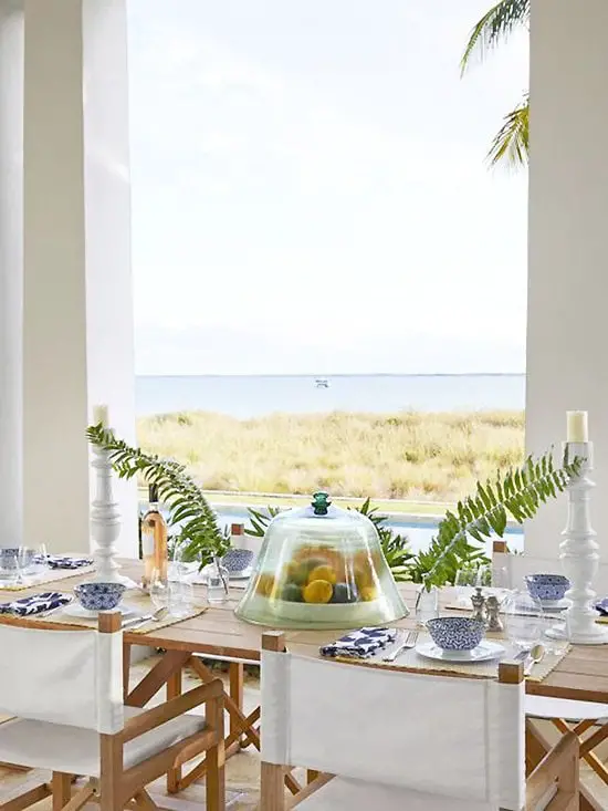 Beach house porch veranda table setting with white directors chairs in the Bahamas by Miles Redd on Thou Swell #porch #veranda #milesredd #bahamas #beachhouse #beach #tablesetting