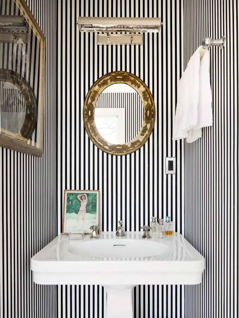 Chic black and white striped bathroom with thin striped and gold antique mirror with pedestal sink on Thou Swell #blackandwhite #striped #stripedroom #stripedwalls #stripedbathroom #bathroom #bathroomdesign #homedesign