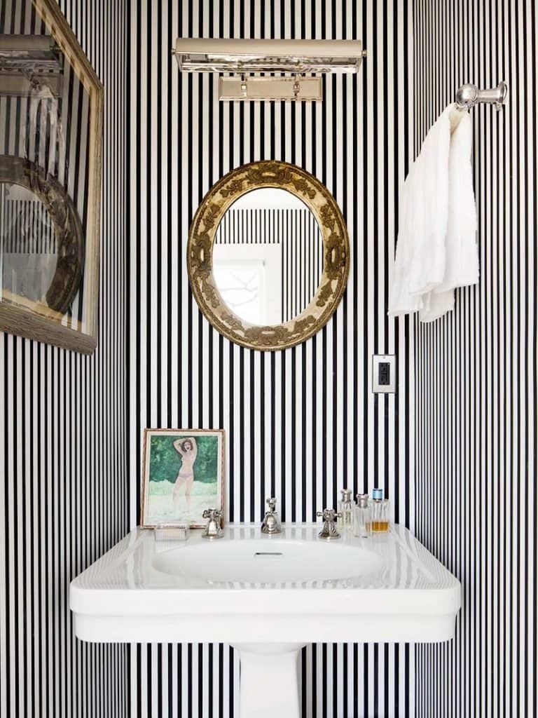 Chic black and white striped bathroom with thin striped and gold antique mirror with pedestal sink on Thou Swell #blackandwhite #striped #stripedroom #stripedwalls #stripedbathroom #bathroom #bathroomdesign #homedesign