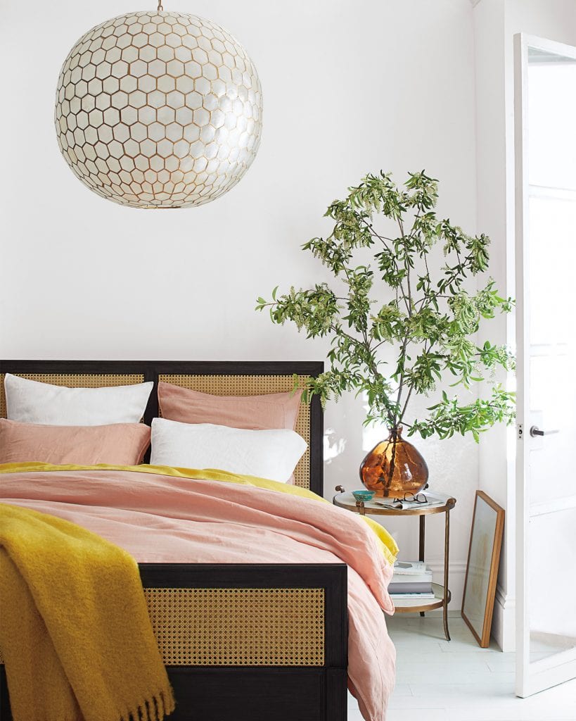 Pink and yellow bedding fall home decor with cane wicker bed and capiz shell chandelier on Thou Swell #bedroom #bedroomdesign #bedroomstyle #pinkandyellow #homedecor