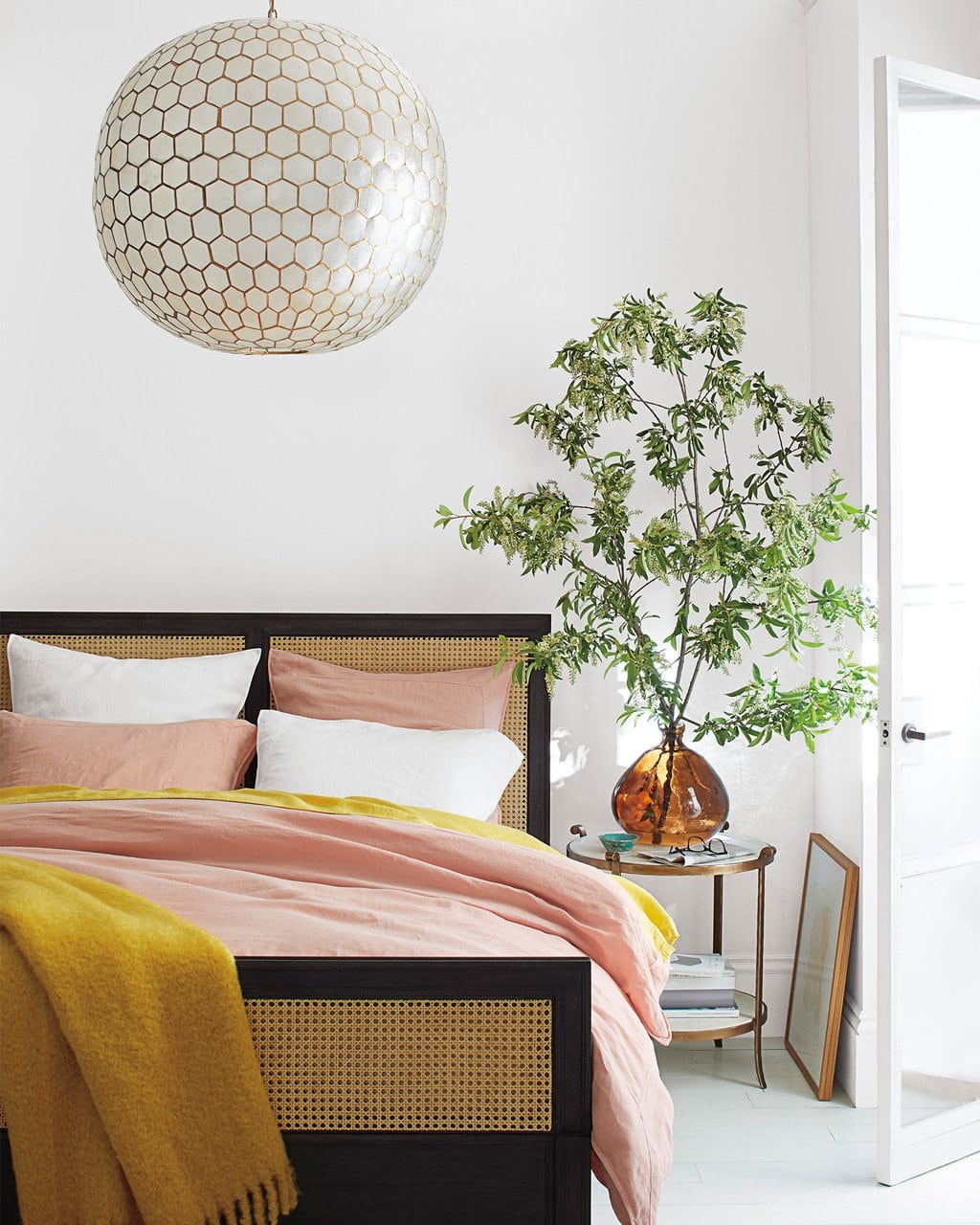 FALL STYLE FROM THE SERENA & LILY FAMILY AND FRIENDS EVENT 5 Pink and yellow bedding in modern bedroom with cane wicker bed and capris shell chandelier on Thou Swell #bedroom #bedroomdesign #bedroomstyle #pinkandyellow #homedecor