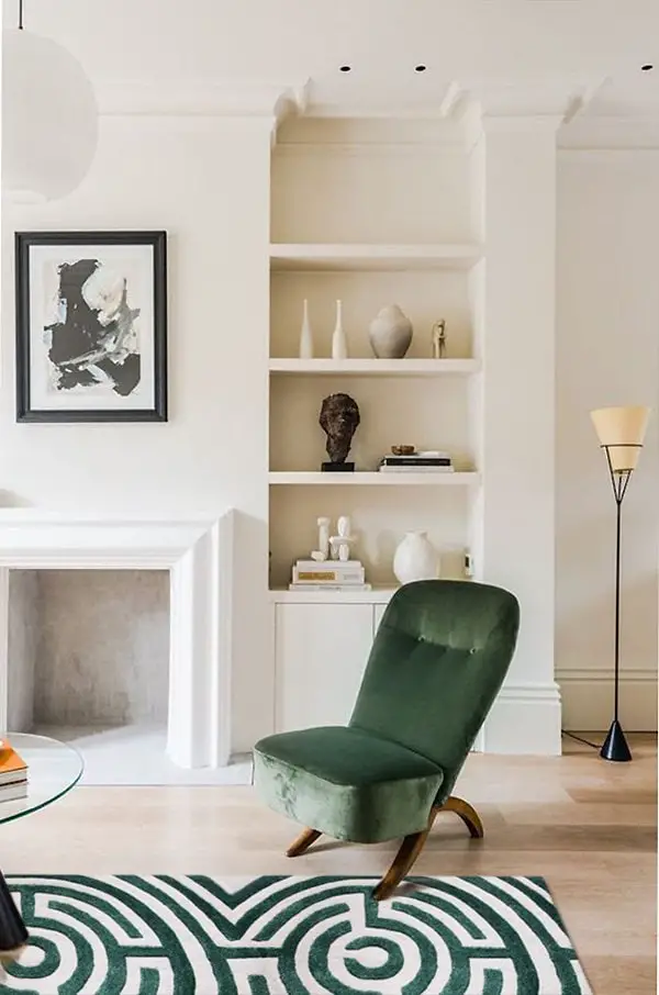 Minimal modern cream living room with green velvet chair and green Lucca maze rug in Boxwood by Kevin Francis Design #arearug #rug #rugdesign #mazerug #maze #luxuryrug #tuftedrug #woolrug #patternedrug #homedecor #homedecorideas #luxurydesign