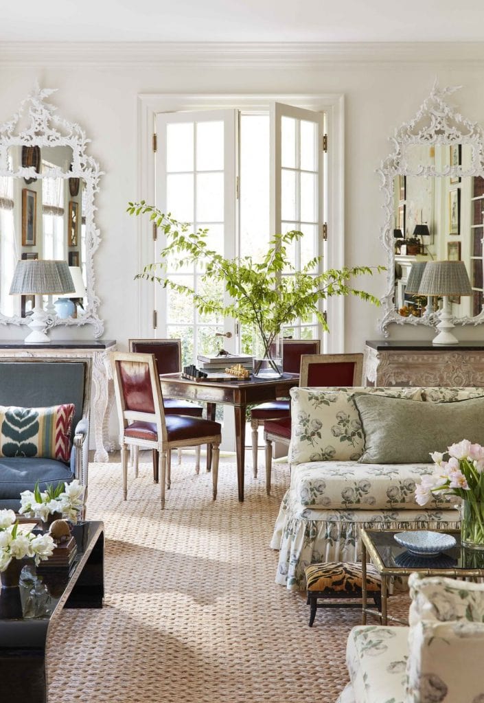 Fresh traditional living room with card table, French chairs, banquette sofa, white mirrors, and glass doors to garden on Thou Swell #livingroom #livingroomdesign #livingroomdecor #interiordesign #homedesign #homedecor #traditionaldesign #traditional