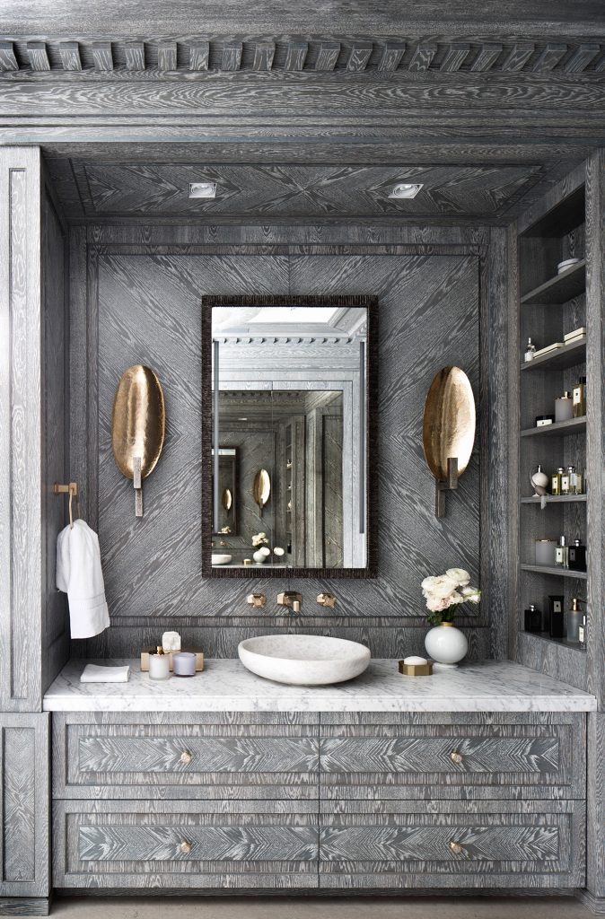 Grey cerused wood bathroom sink vanity with copper sconces and built-in shelves by Russian interior designer Catherine Fedorchenko on Thou Swell #bathroom #bathroomdesign #cerusedwood #custombathroom #luxurybathroom #luxurydesign #luxuryinterior #interiordesign