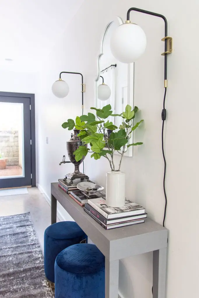 Modern entryway design with AllModern grey console table, blue velvet stools, and sconce lights on Thou Swell #entry #entryway #entrywaydesign #entrywaydecor #entrydesign #allmodern
