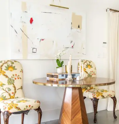Round marquetry dining table from Anthropologie outlet in Georgia in apartment entryway with abstract painting and floral dining chairs by Kevin O'Gara on Thou Swell #entryway #diningtable #roundtable #marquetry #anthropologie #homedecor #interiordesign